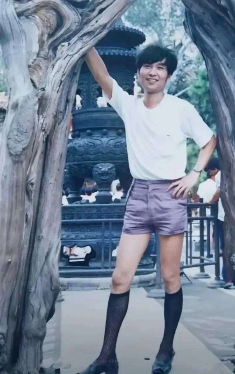 上世纪80年代，一个穿着短裤黑丝网袜的小伙子在旅游景点的留影。
这个小伙子打扮太