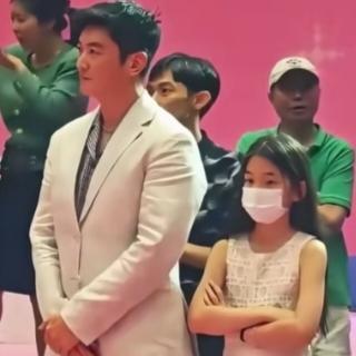 小姑娘，双手交叉抱在胸前，就那么大大方方地站着。
镜头怼过来，她也根本不管，眼睛