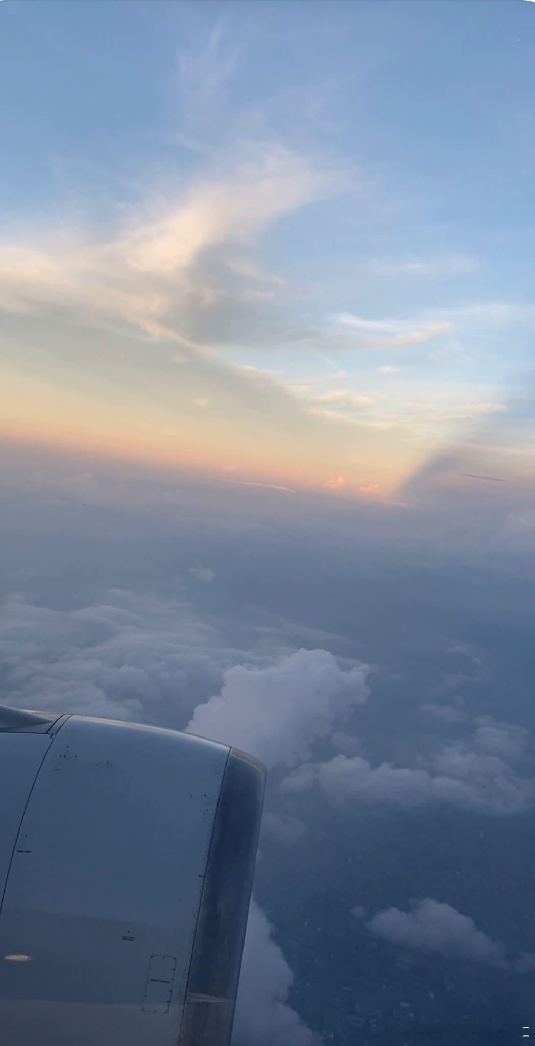 飛在雲端，剛好遇見天空最溫柔的時刻。☁️✈️夕陽躲在雲層後面，灑下一片淡淡的金色