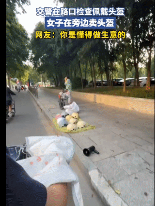 最懂做生意的人出现了，前面交警在查头盔，女子在后面摆起了头盔生意，还说这是以备不