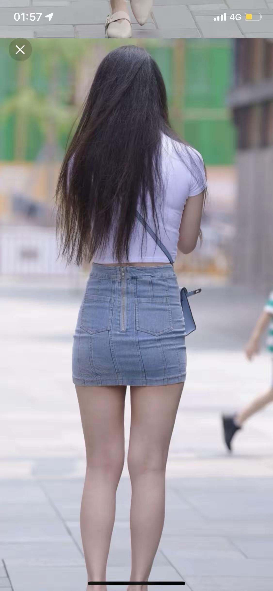 长发如瀑垂落腰间，白T和牛仔短裙把夏日的松弛感穿在身上，背影里藏着不回头的温柔步