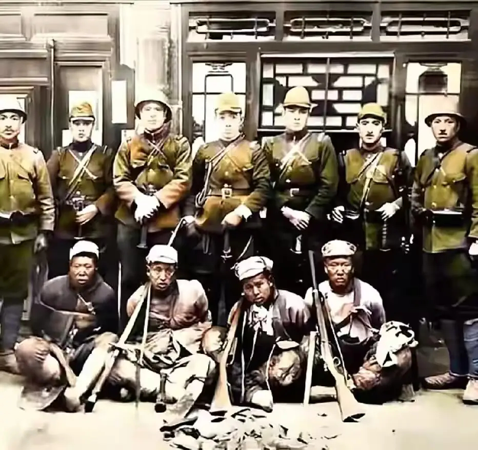 1937年，日寇正洋洋得意，将武器搭在被俘国军士兵肩膀上以示羞辱 