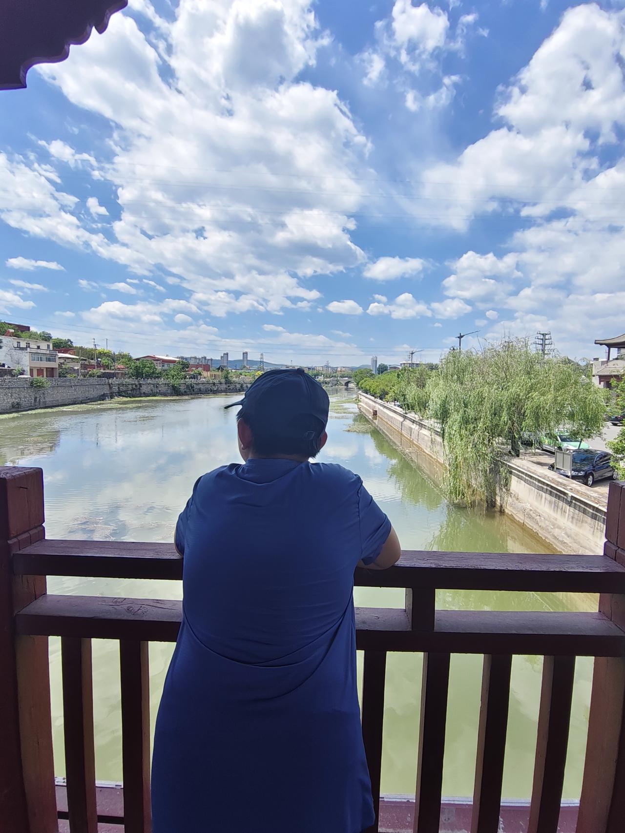 站在桥上看风景的少年
这张照片是在南响堂山石窟前的廊桥上拍摄的。
图中那位少年就