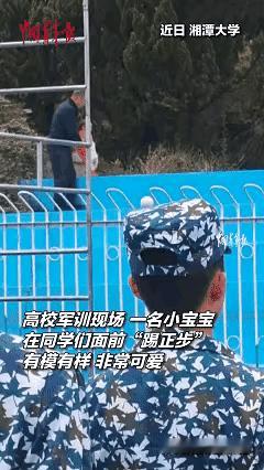 这个场景真是既温馨又有趣！教官刚刚对同学们的正步表现满意，结果一抬头看到操场边上