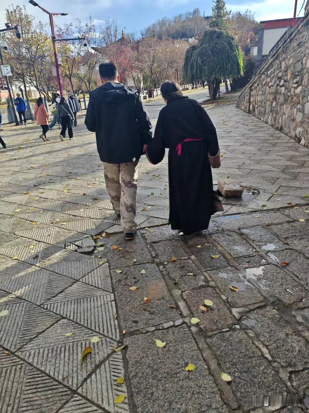       藏族寺院里，一个高大的小伙子，一直牵着一个藏族老奶奶的手。
    
