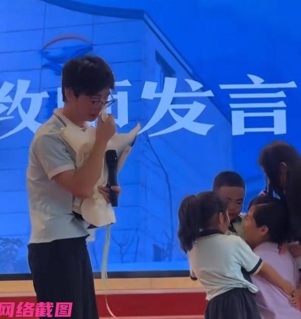 某幼儿园毕业典礼上，有名戴眼镜的男老师被孩子们抱着他泣不成声，此刻男老师也流泪有