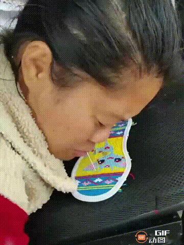 重庆一处街头，一位残疾妈妈直接用嘴代手来缝制鞋垫，只见她嘴里咬着针，缝完一面后，