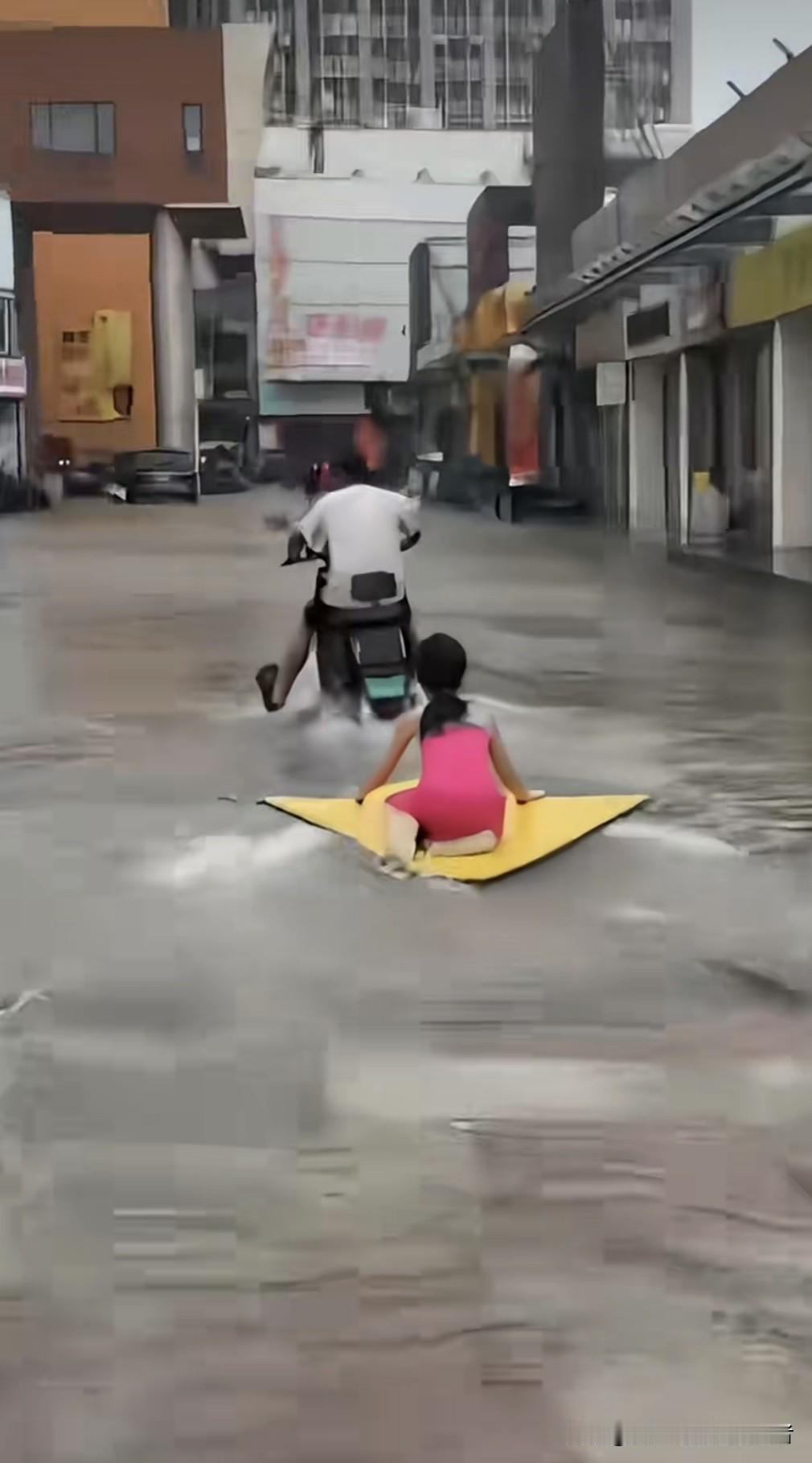 台风天里，这对父女把内涝玩成了“海边度假”！

江苏暴雨，城市积水严重，可这位年