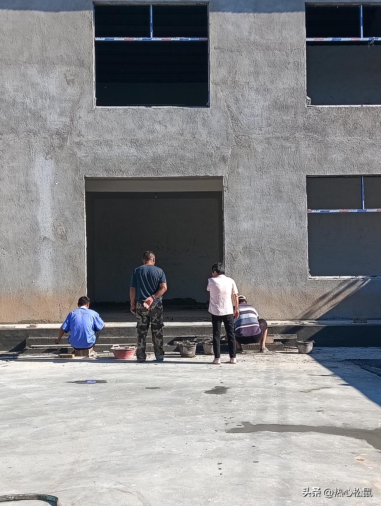 工人们在墙上做装修做台阶呢。