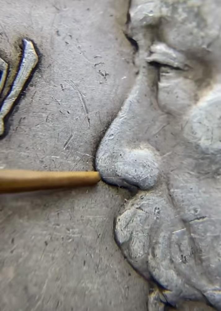 大家注意看这两枚银币，竹签所指的鼻梁和胡须额头轮廓线条差异，特别是银元空白位置。