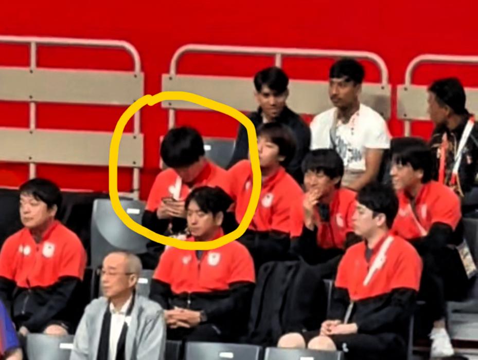 亚运男单决赛看台观赛，日本队员排排坐。松岛辉空认真观赛，张本智和低头看着手机，负