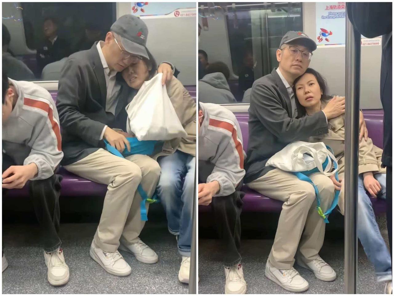 地铁上，一位穿着西服的男子搂住自己的妻子，并用一只手轻轻地拍打着她的后背，妻子的