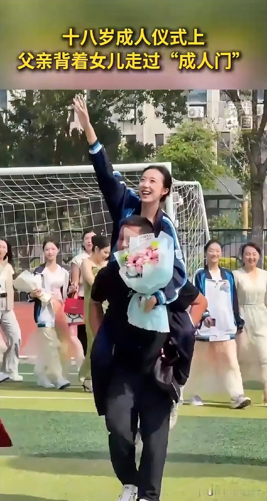 一个中学举办18岁成 人仪式，

仪式现场，

一位父亲稳稳背着

女儿缓步走过