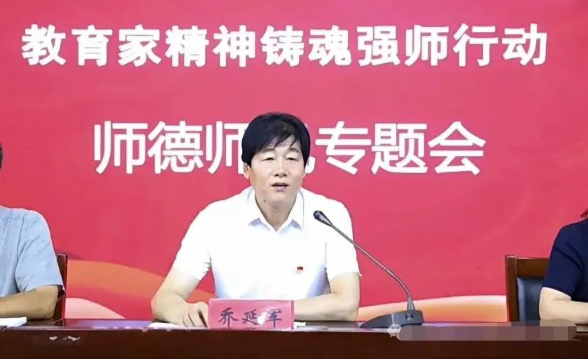 真是讽刺！这就是邯郸某中学校长乔延军，他端坐在讲台上大讲特讲，后面“师德师风”几