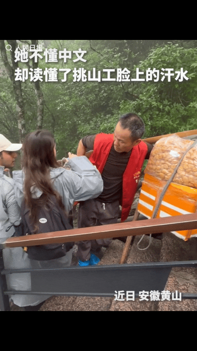 上人民日报了！近日，安徽黄山，外国游客下山时偶遇挑山工休息，突然她拿出一瓶水，拧