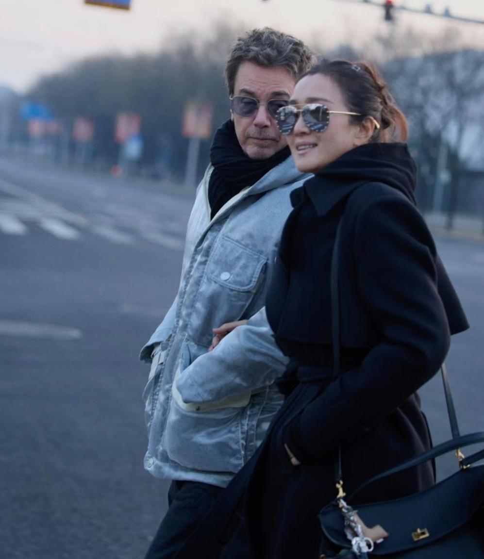 刚刷到几张图，59岁的巩俐与77岁的丈夫米歇尔在北京中轴线并肩漫步，成了街景里最