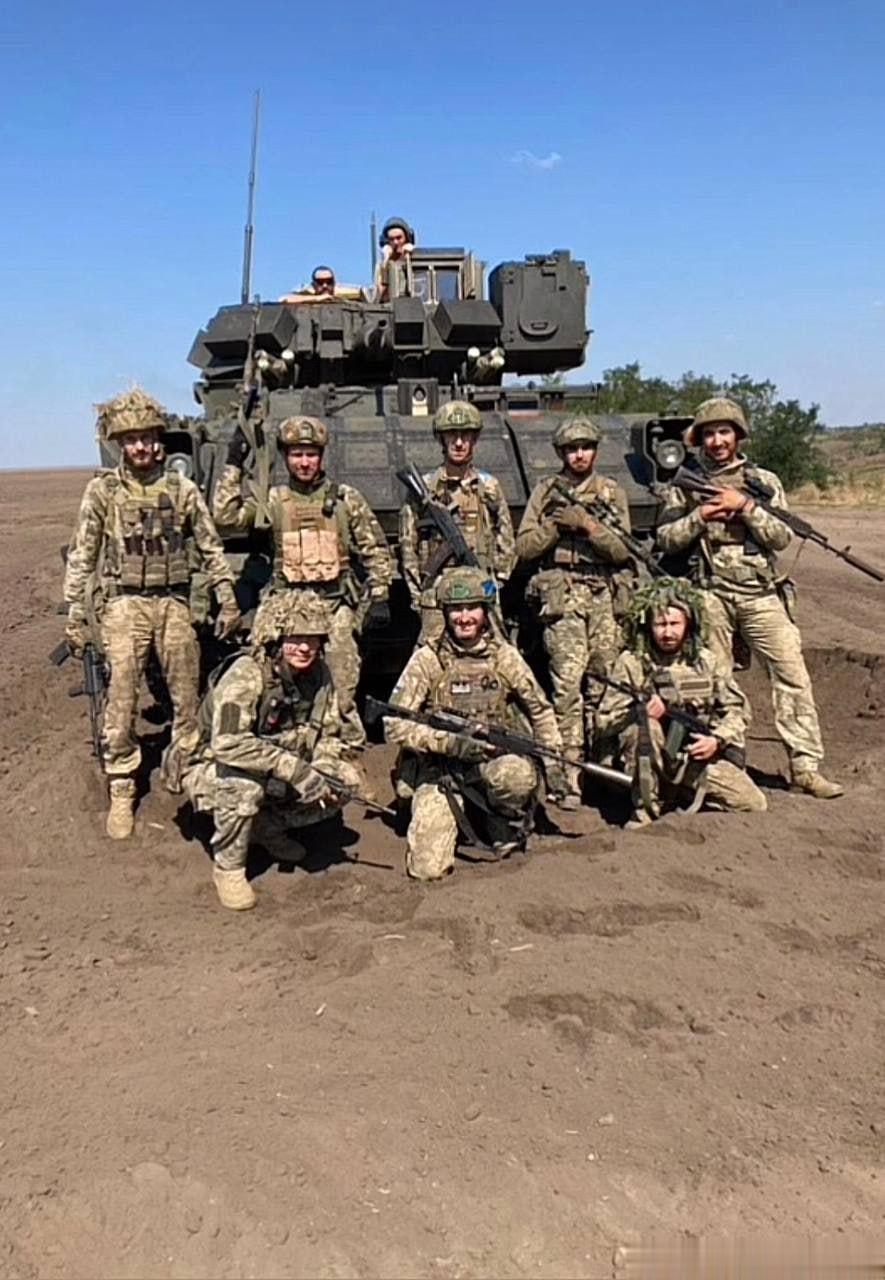 乌军士兵在一辆少见的加装了BRAT套件的布雷德利M7 BFIST火炮支援车前合影
