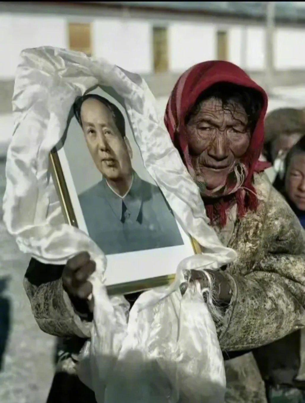 一藏民乔迁新居，所有的家俱都用车搬运。唯有伟人像，用洁白的哈达包好，捧在怀里，一
