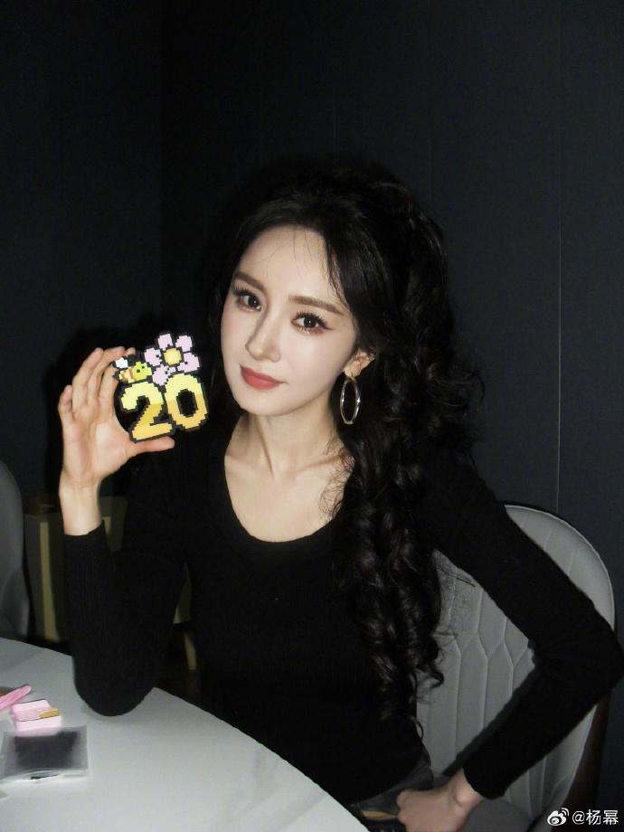 杨幂微博晒近照，配文：EP71:生日快乐。身穿黑衣，手持油菜花太美了！扎高马尾梦
