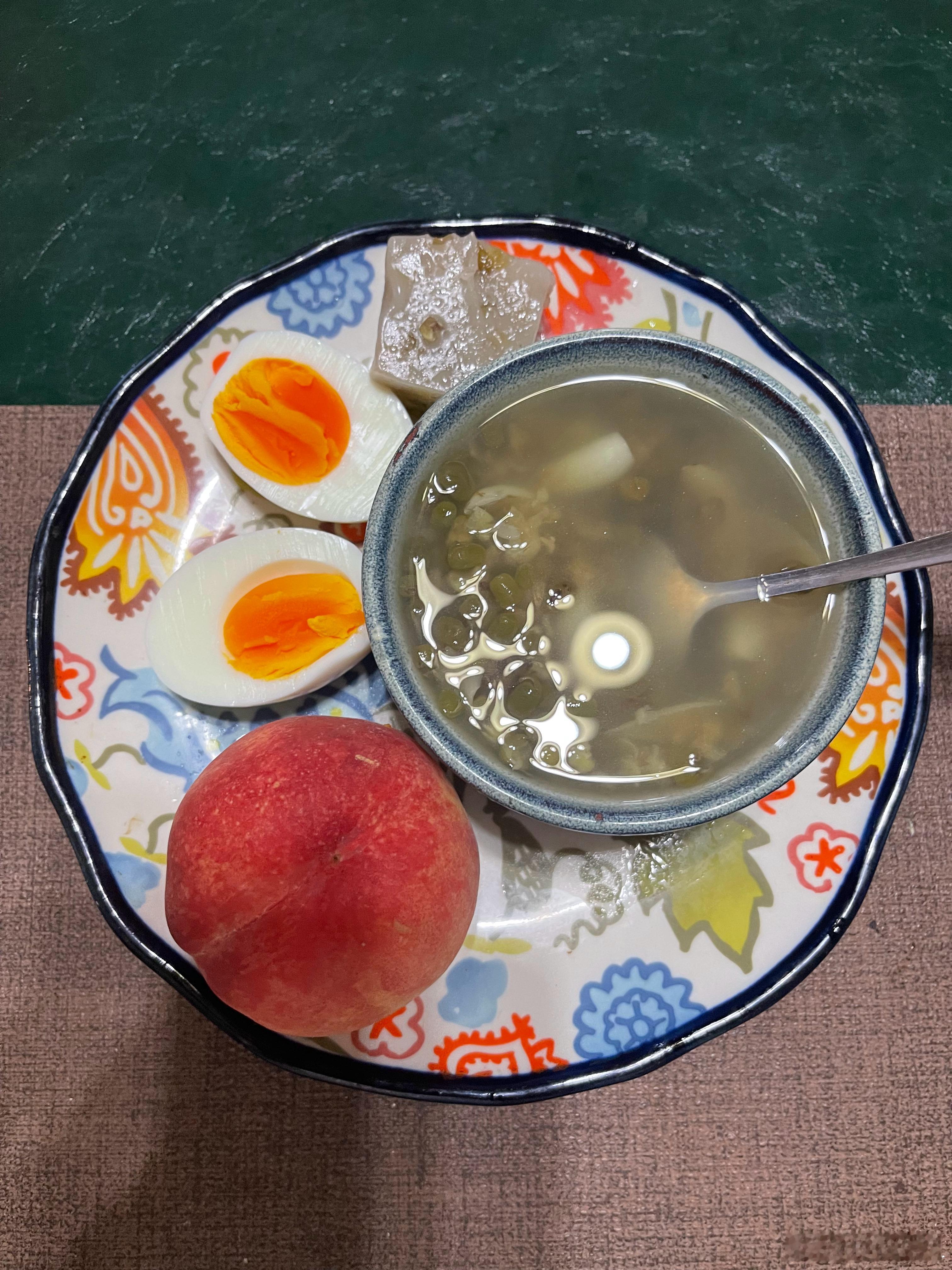 今天的早饭溏心蛋、一块拉糕、一个水蜜桃、一小碗绿豆百合汤，夏天了可以绿豆汤常喝这