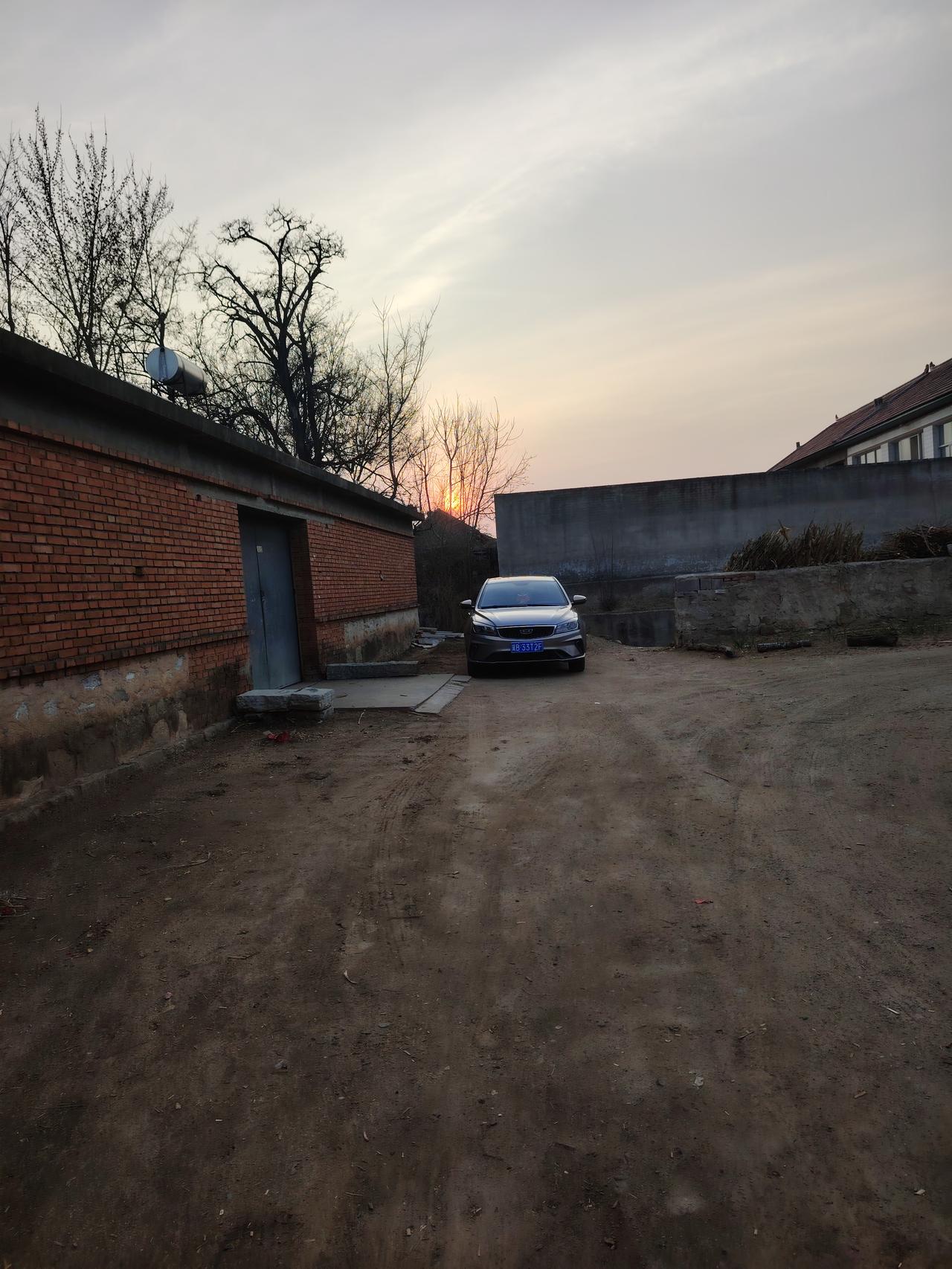 冬日黄昏，静谧乡村小路，汽车停靠在红砖墙旁，岁月静好。