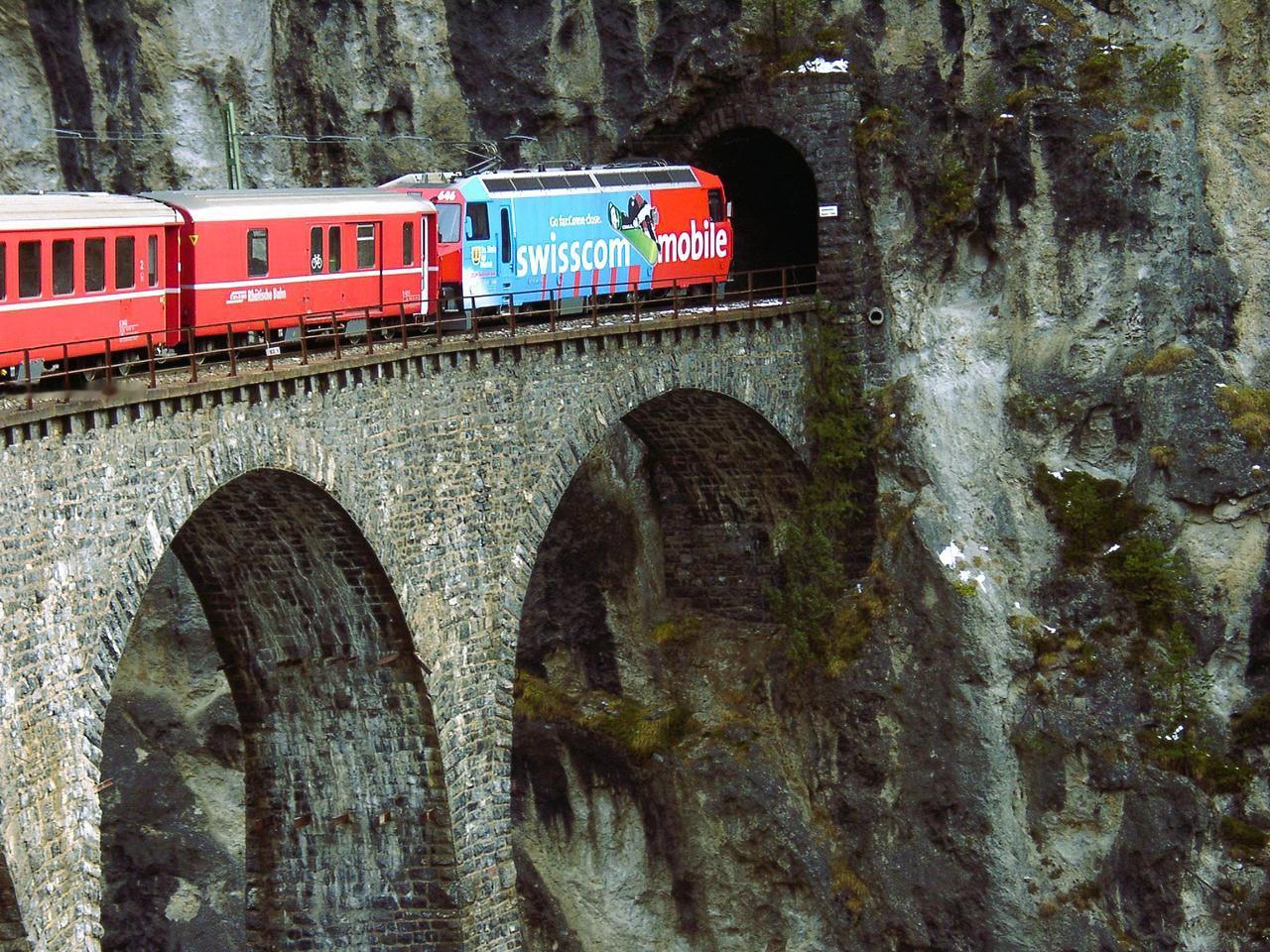 这是2000年瑞士火车旅行的老照片，部分车厢还保留可开窗户。火车正穿过一座桥，桥