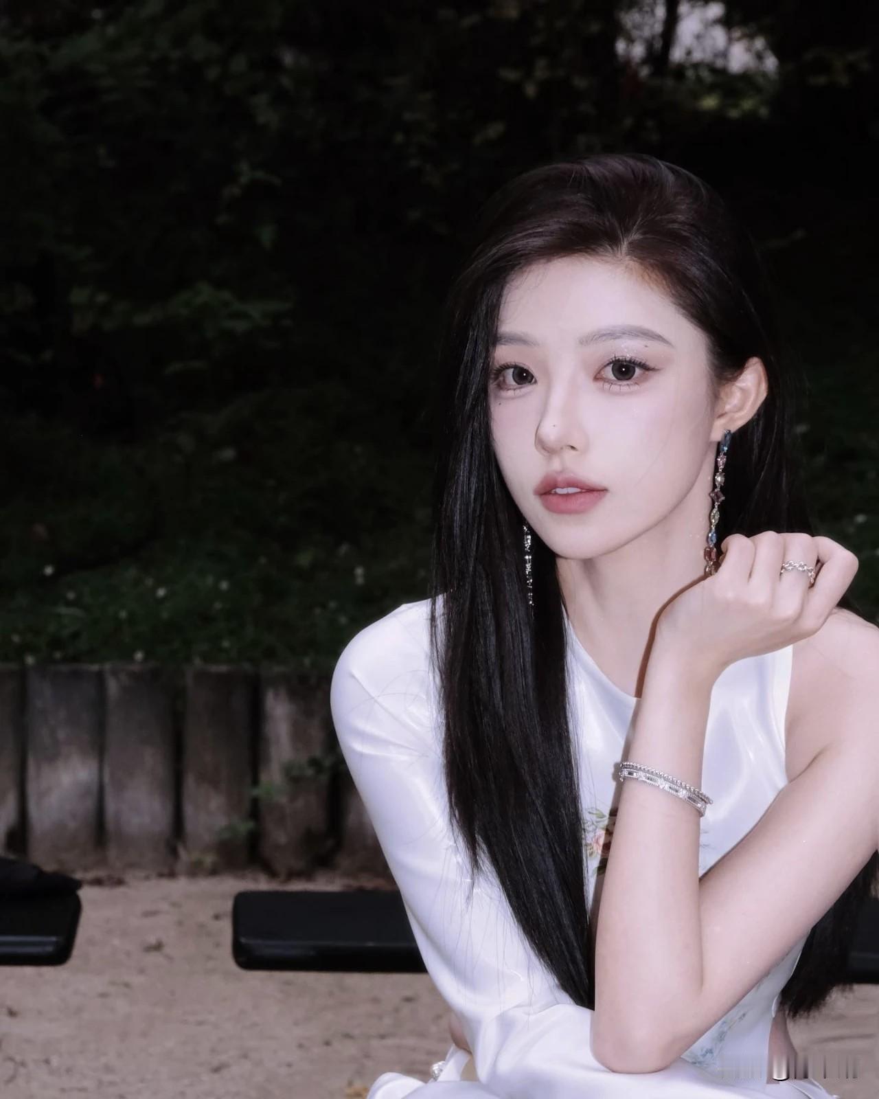 一袭白衫裁月色，青丝垂缕惹风柔。
眸凝秋水藏星子，唇绽丹砂带露羞。
腕底银环摇碎