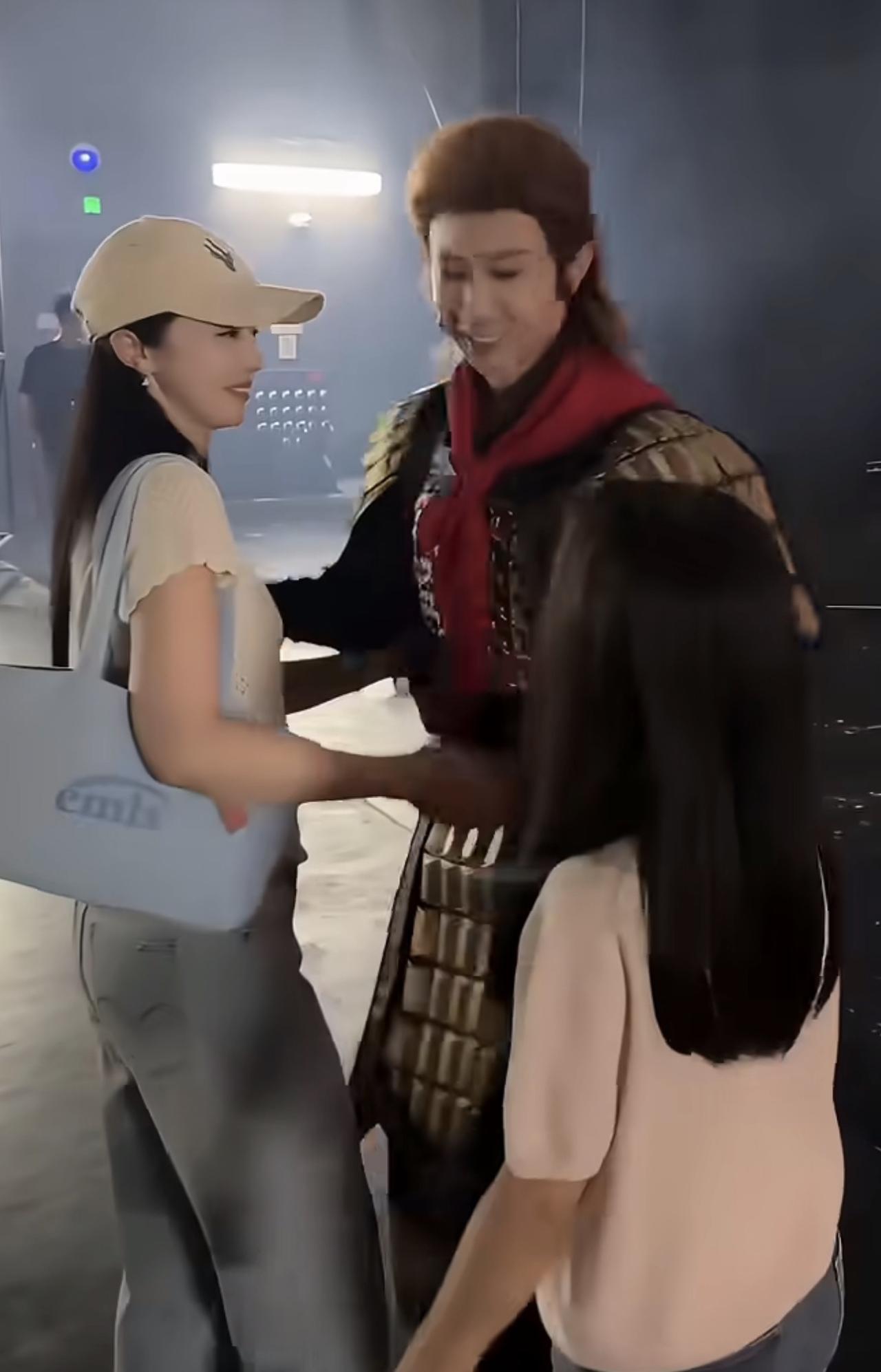 场景： 舞台剧后台门口，张维伊刚谢完幕，董璇牵着小酒窝迎上去，周围还有剧组人员在