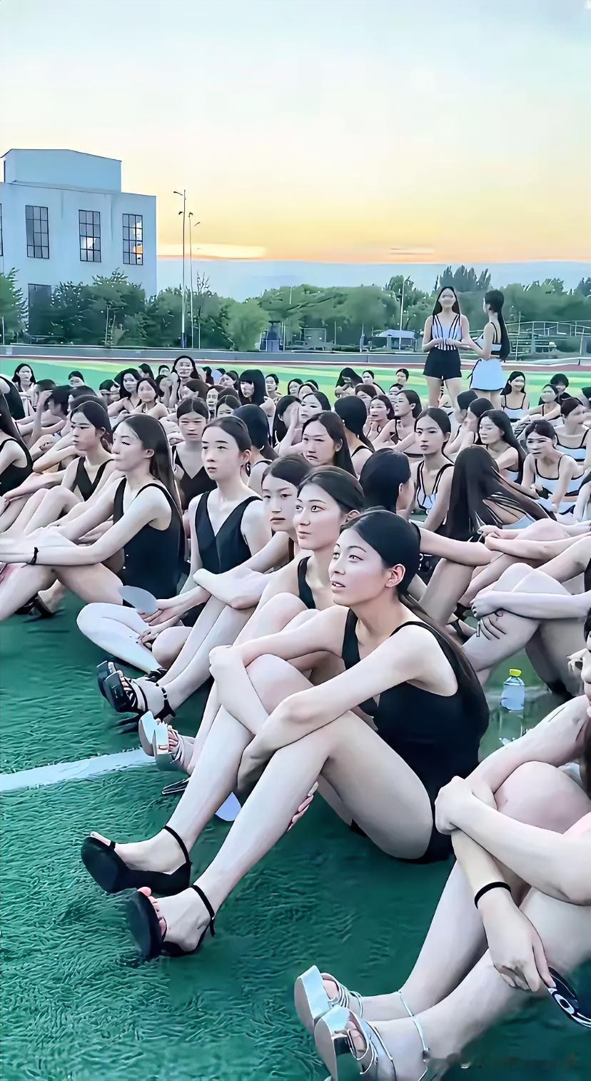 黄昏把操场晕成暖金色，上百位女孩穿着统一的黑练功服席地而坐，没有喧闹只有专注的眼