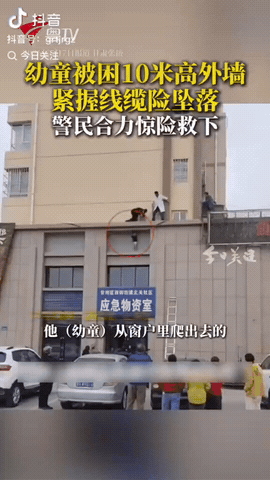 5月6日清晨，甘肃张掖甘州区，一穿着纸尿裤的宝宝被困10米高外墙，他的双手抓着电