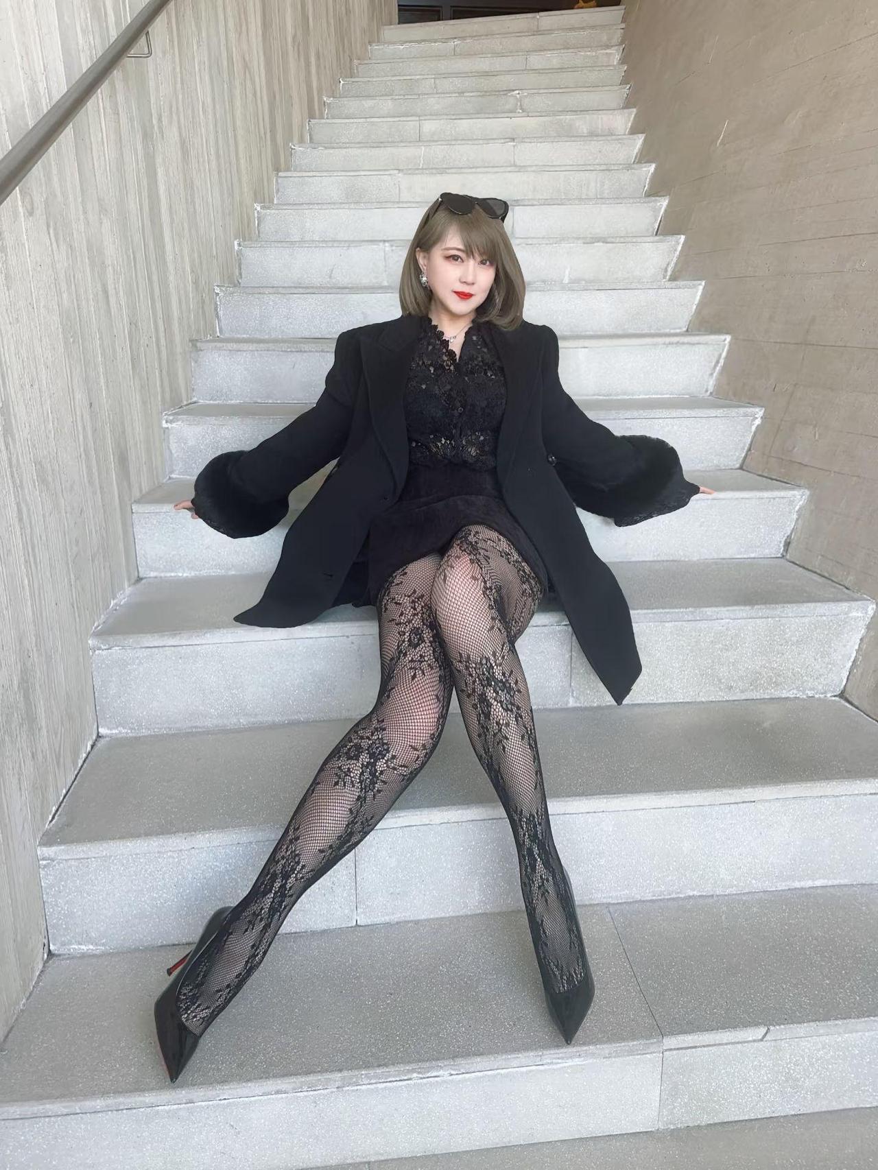 黑衣美人坐台阶，红唇轻启似有话。