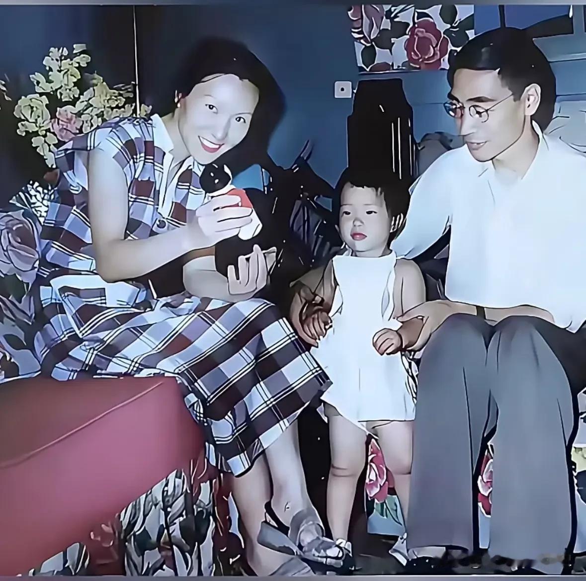 这是郭永怀、李佩一家三口温馨的居家合影。
画面中，李佩身着格纹连衣裙，笑容明媚而