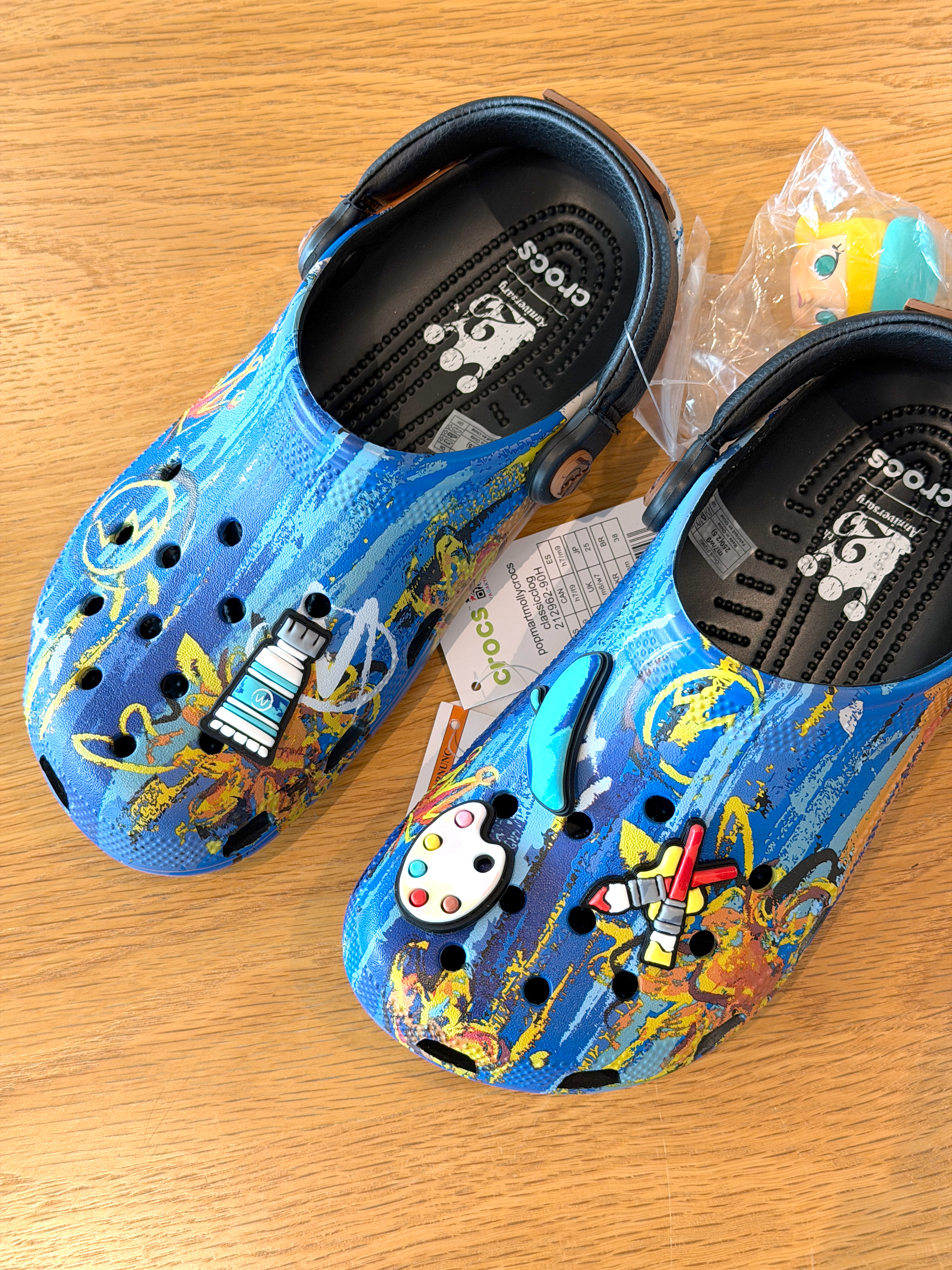 Crocs和泡泡玛特的MOLLY联名系列，小画家主题。鞋面满铺画作，仿皮质后跟带