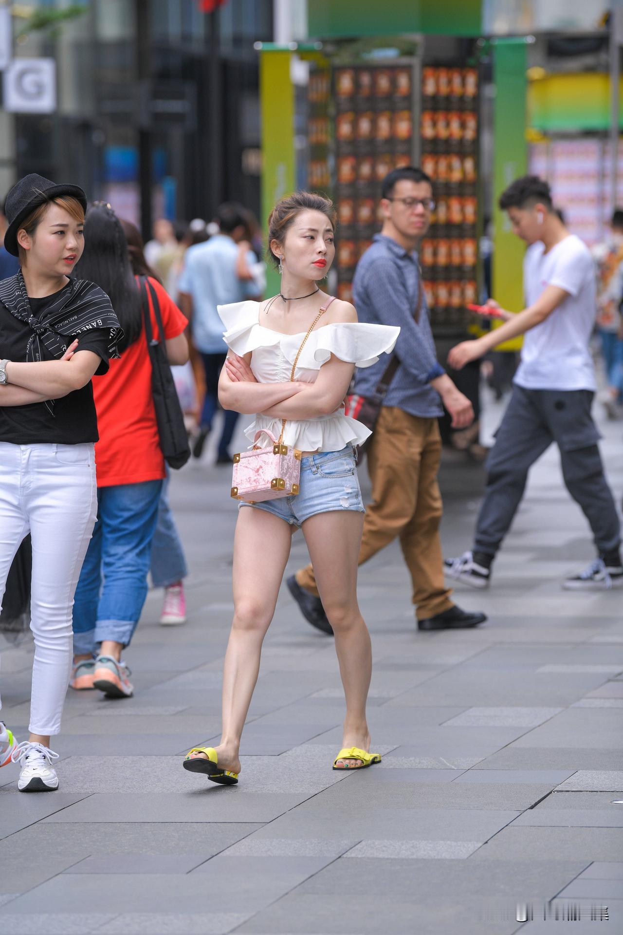 街头美女穿着时尚，引人注目。
