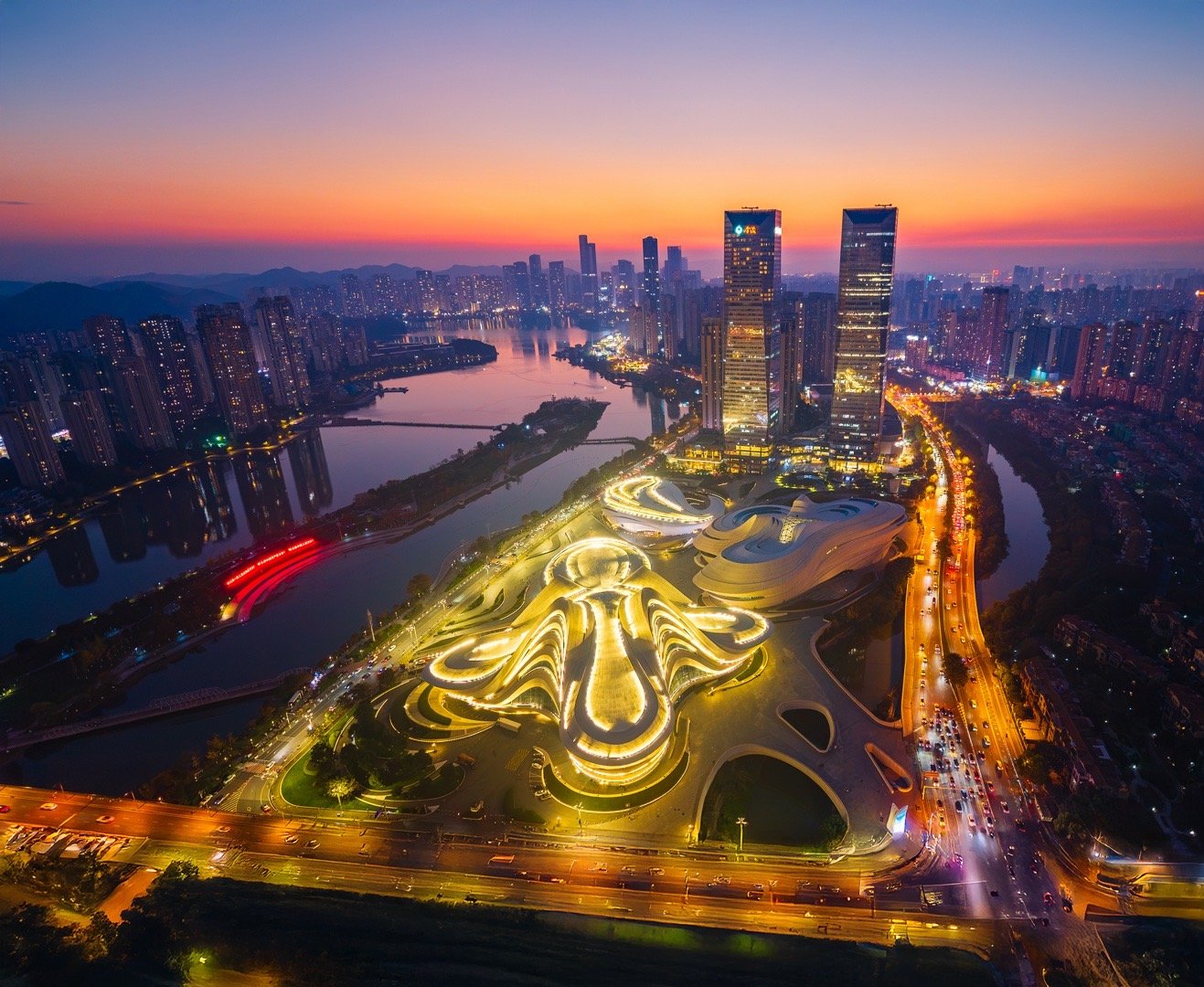 长沙梅溪湖的傍晚蓝调时刻，是摄影绝佳时机。用无人机航拍大剧院的流线型轮廓、金茂大