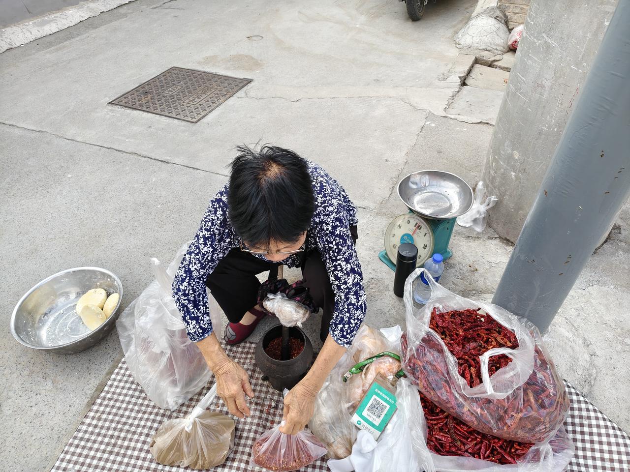 今天终于在运城盐湖西街早市，又一次看到了这位大婶。她坚持手捣辣椒，把最原始的辣椒