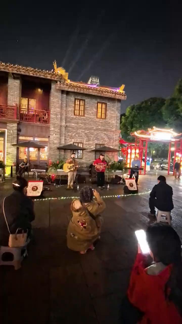 在街头看艺人演唱。
风伞摄制。
我们会唱歌，家人们好吗？