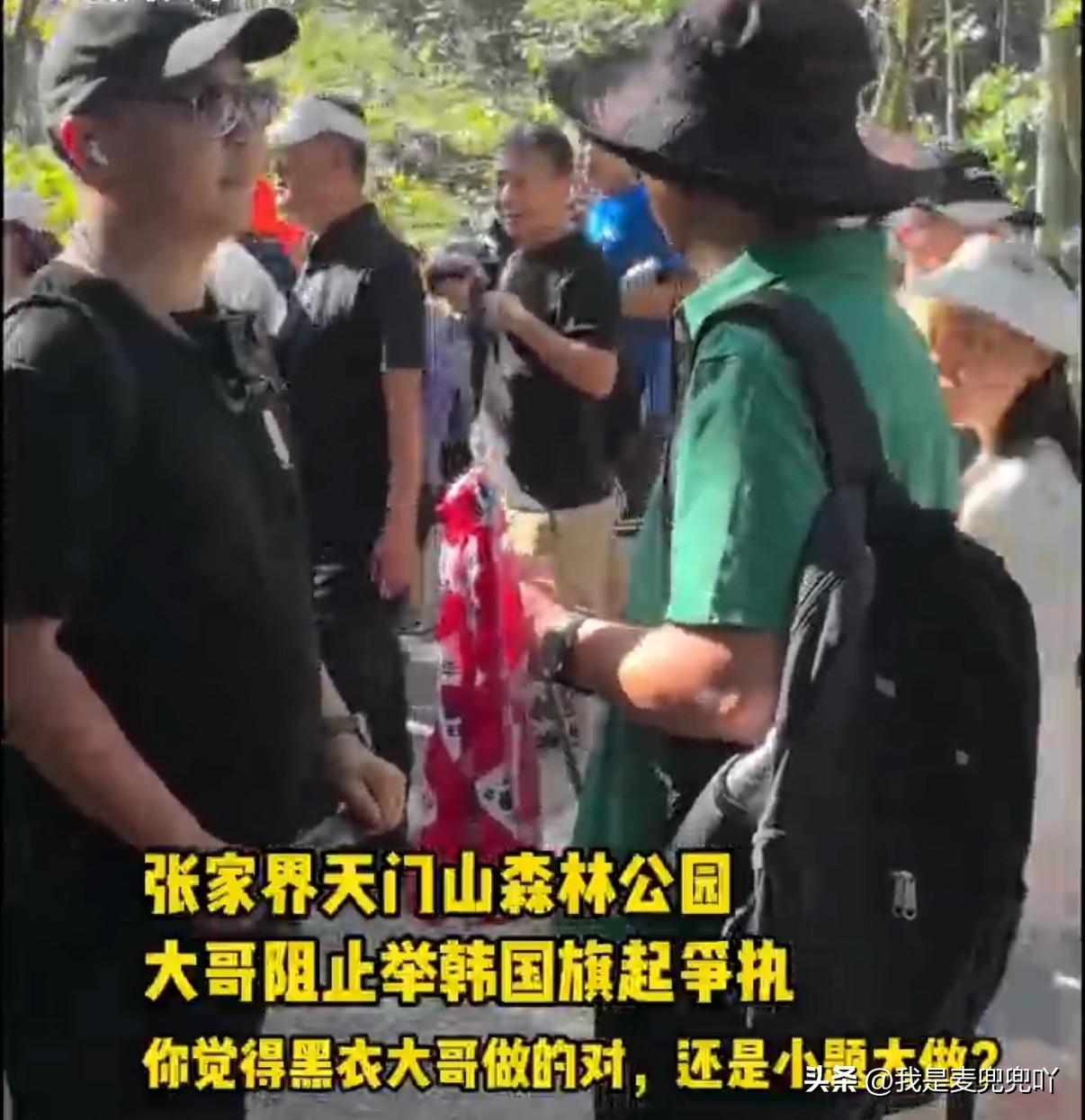 张家界一导游因带队韩国游客，导游旗用了带有韩国国旗图案的旗帜被一黑衣男子拦住要求