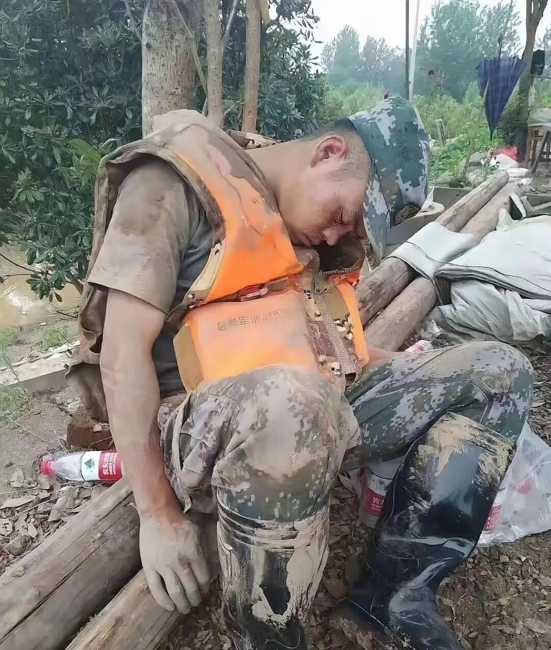 这张照片让无数人泪崩，一个满身淤泥的战士，累的靠在一棵树旁睡着了。
​​每每看到