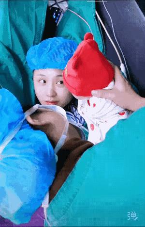 年轻妈妈刚生完就被护士把娃抱到胸口，她脸还湿着，手抖着摸那红通通的小脸，眼泪啪嗒