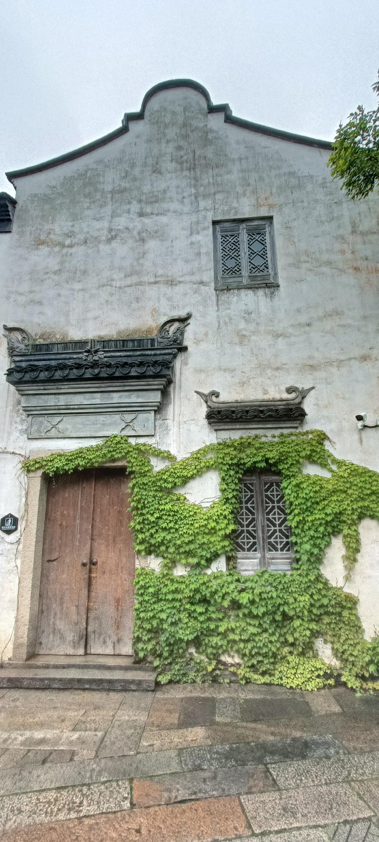 古朴的青砖白墙，爬满绿藤的静谧小院，仿佛时光在这里停驻。
上联:绿藤掩映古墙，