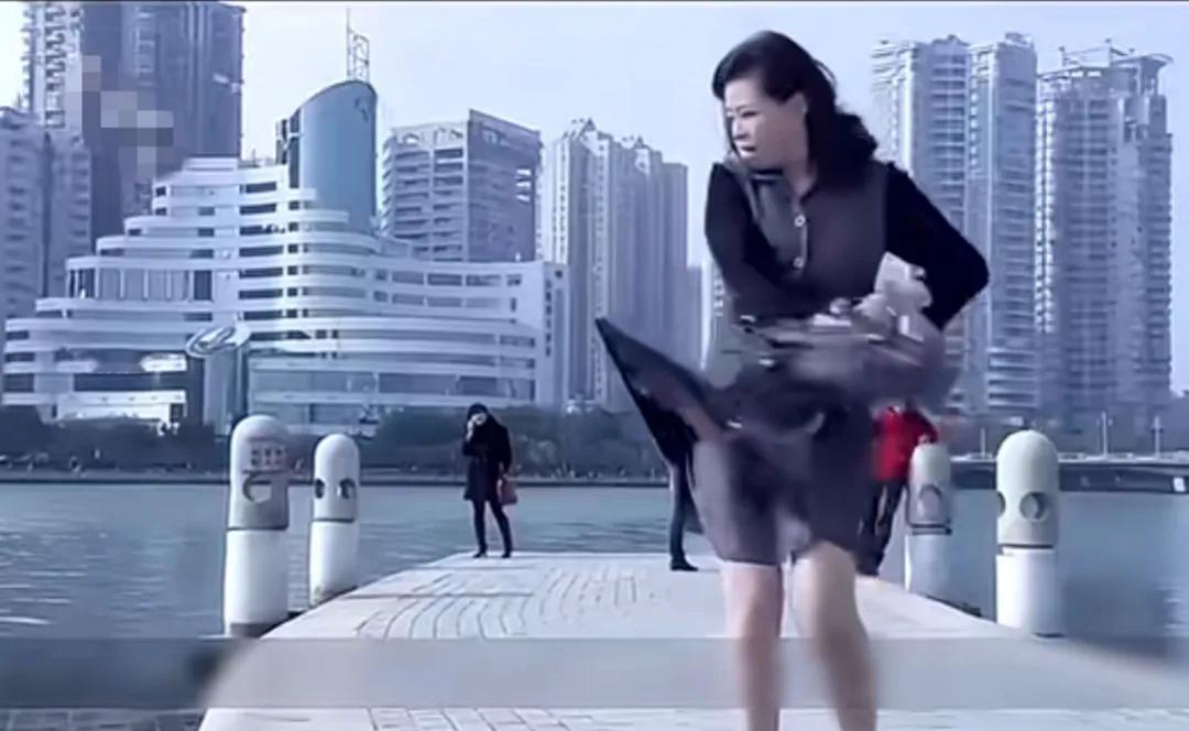 男子路边钓鱼甩杆时，钩子钩住了正在路过女人的裙子，他上前把钩子取掉，正要甩杆恰好