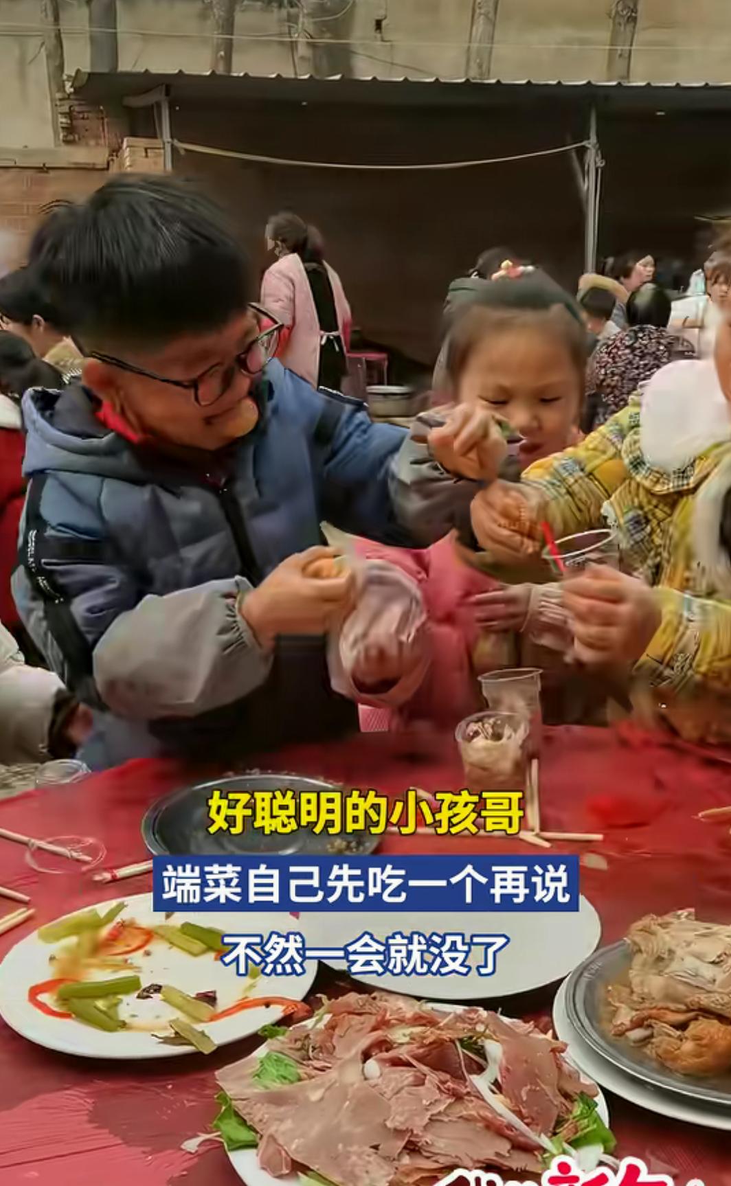 好聪明的小孩哥，端菜自己先吃一个再说，不然一会就没了
旁边的人笑着说“这孩子聪明