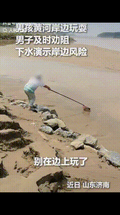“上人民日报了。”山东济南，小男孩在黄河岸边拿着抄网在泥沙里捞着玩，一名手持长棍