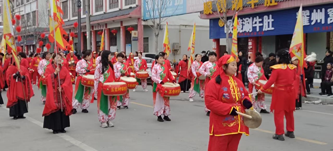 晒图笔记大赛红妆列阵，彩旗引路，五台村锣鼓队的巡游队伍点亮了街头。铿锵鼓点踏碎冬