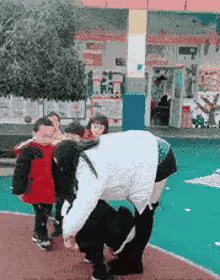 幼儿园的老师做出这个动作，看着有一定的风险，为什么要玩这样的游戏呢，万一失手的话
