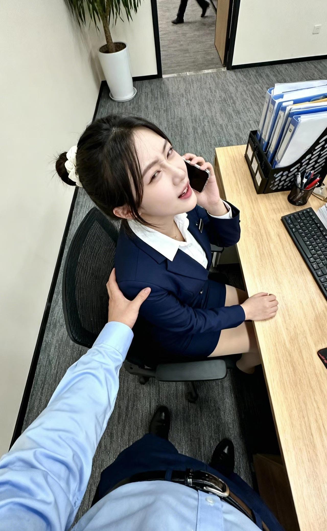 上联
蓝裳素雅临工位，眸转间，手机贴耳应客问
下联
手搭肩柔传暖意，笑生时，职业