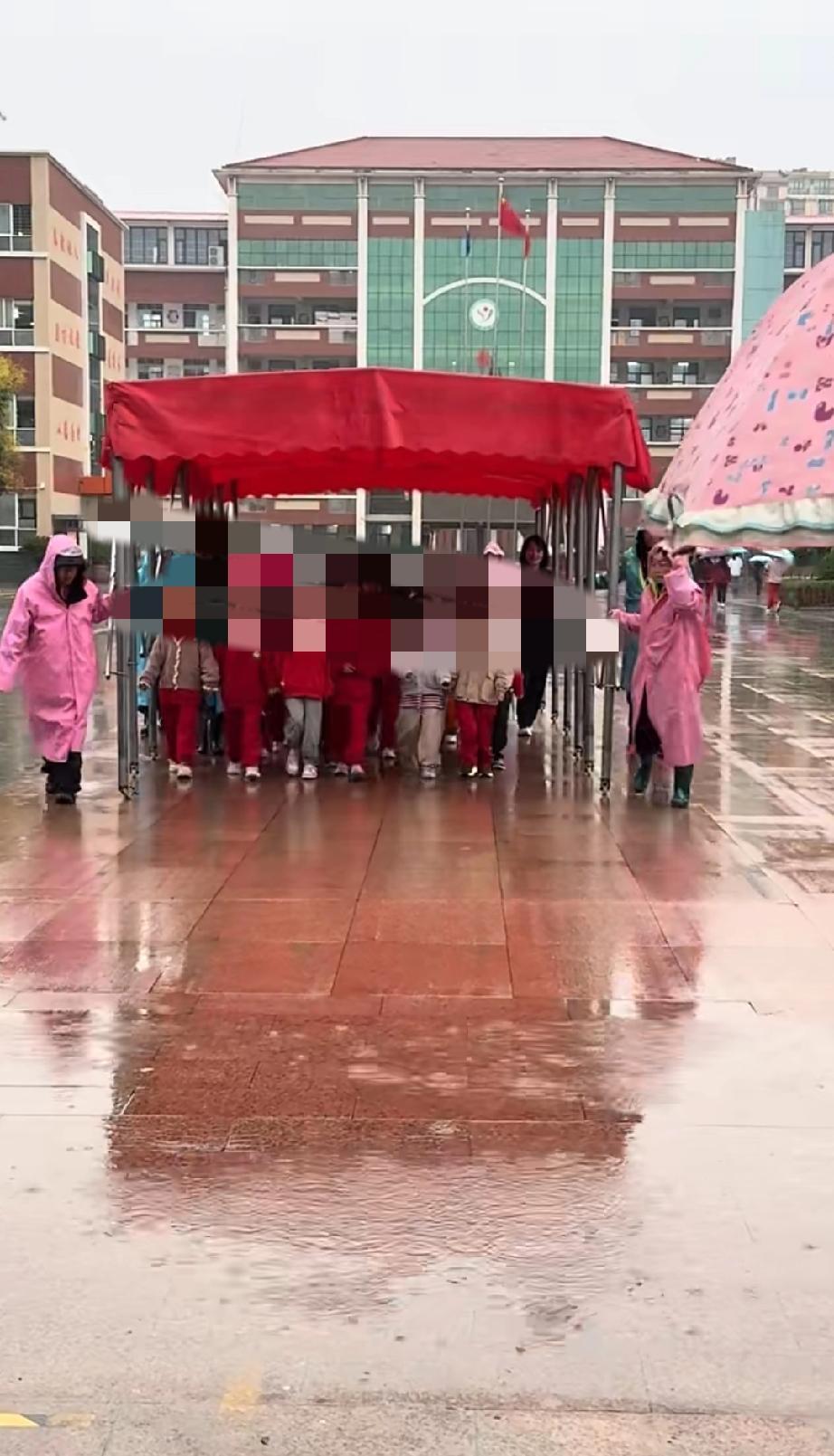 某小学下雨了，老师雨逄护送，这是一小部分不上晚自习的孩子，为了避免孩子淋雨，提高