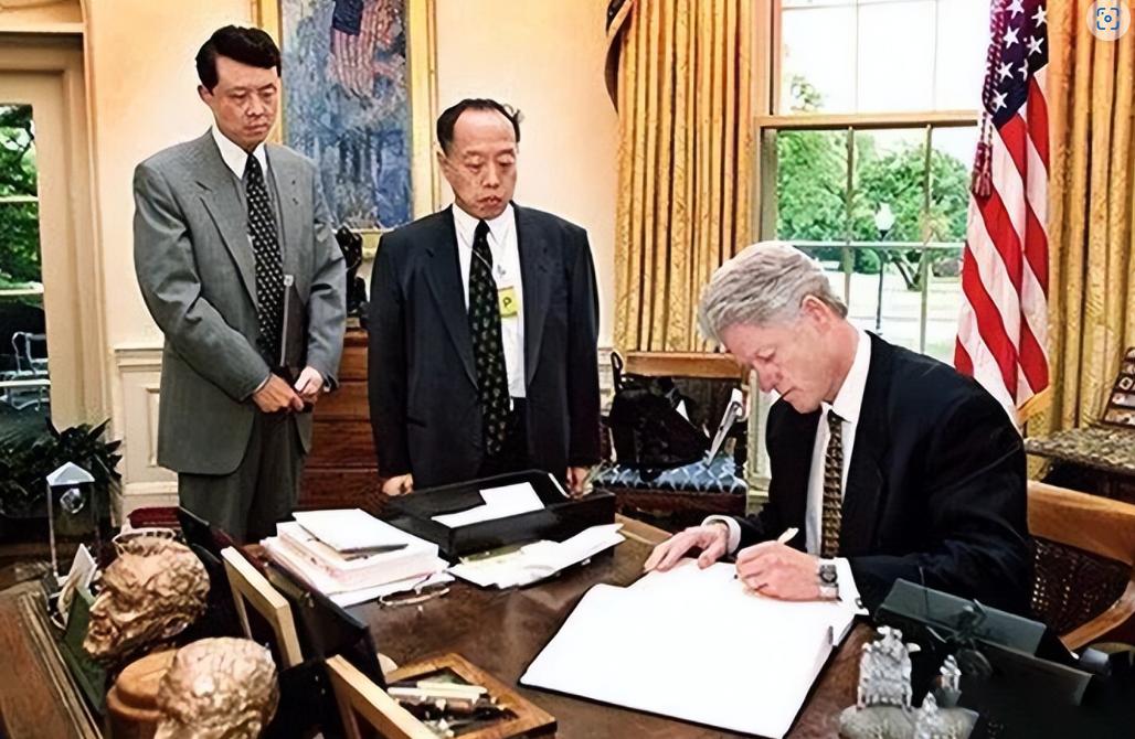 1999 年 5 月 13 日，华盛顿白宫，美国总统克林顿拿起笔，在一本吊唁簿上