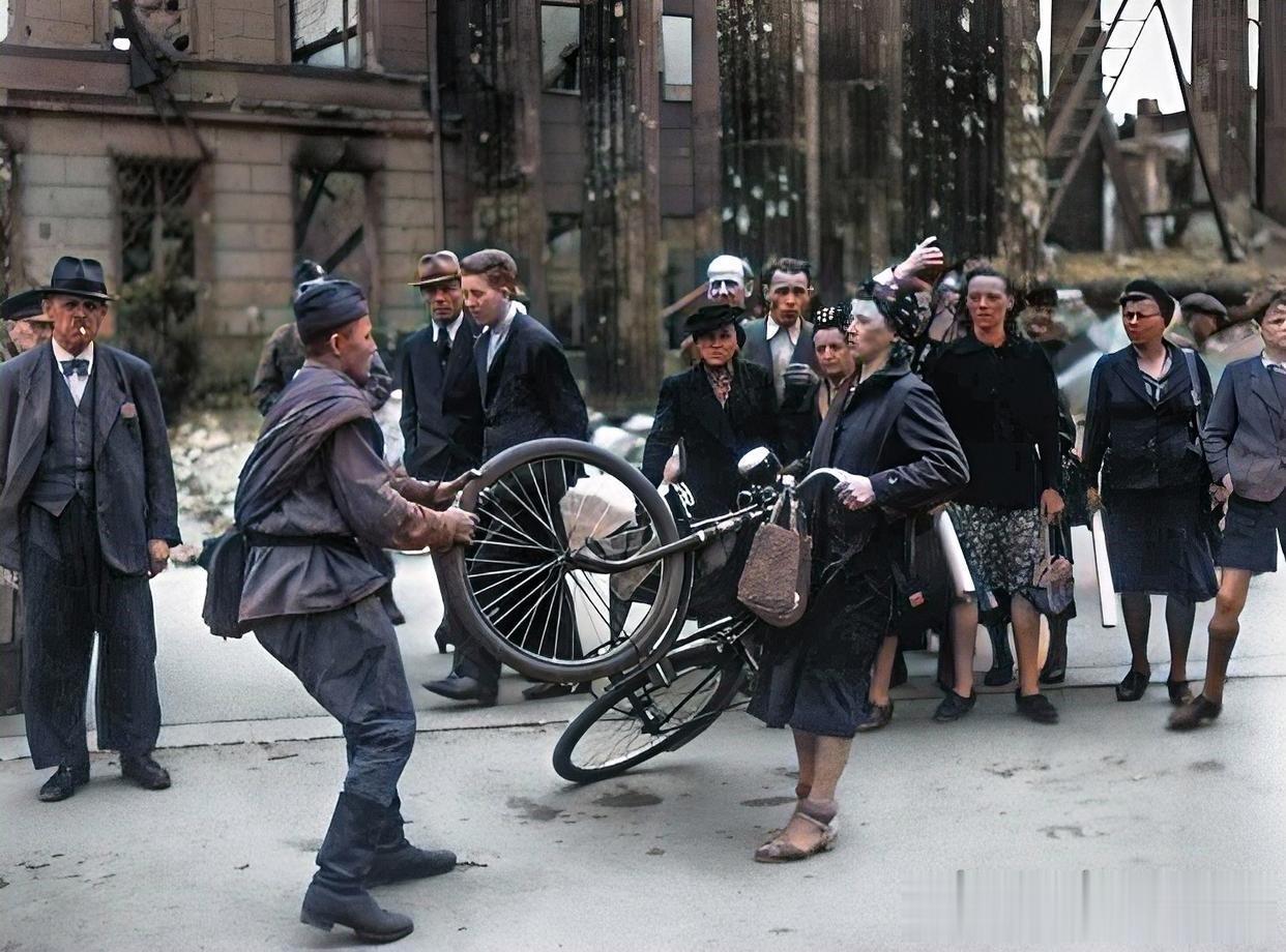 1945年，德国柏林，一名苏联士兵正在街头调戏德国妇女，周围的德国人站在旁边只能